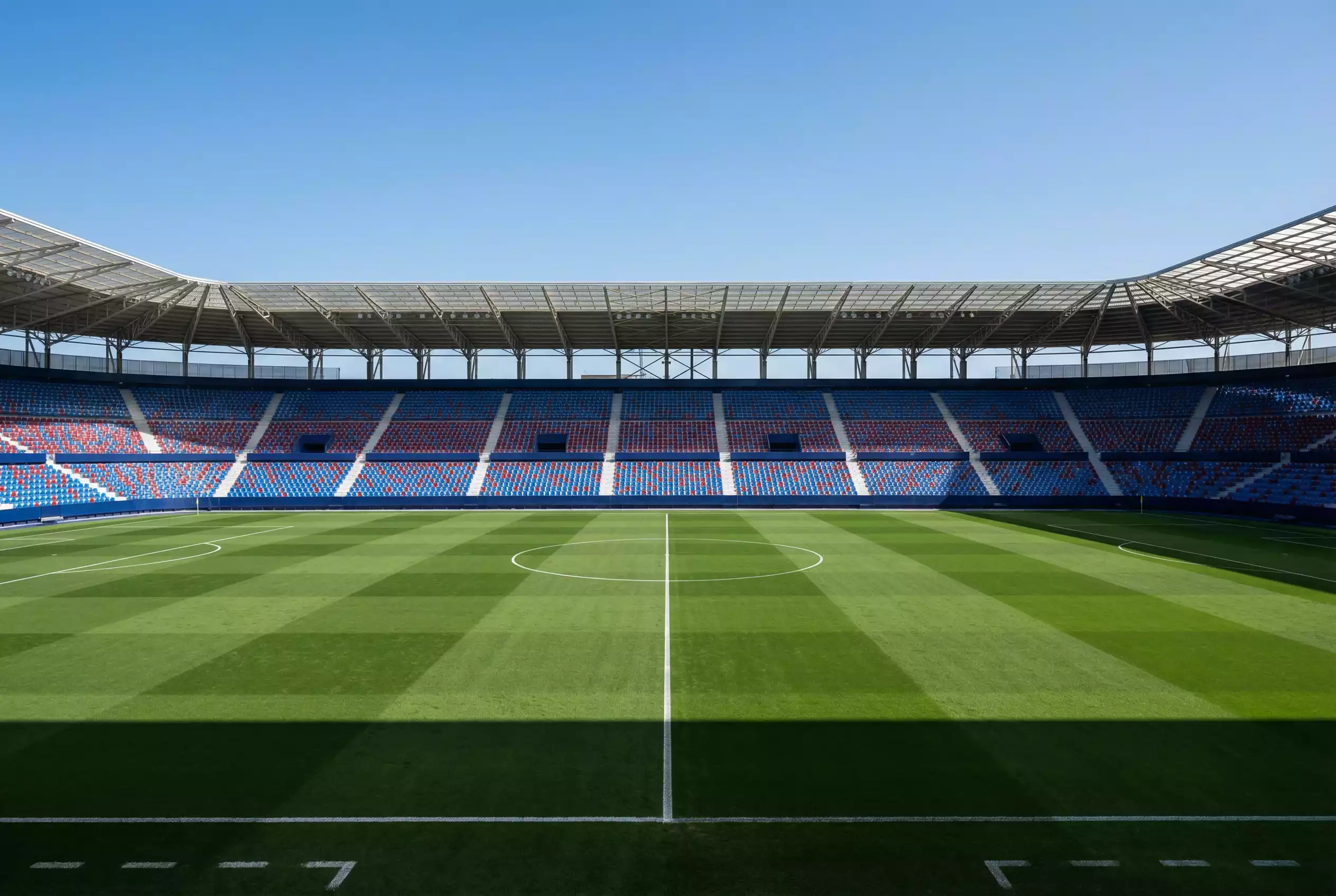 Campo de fútbol de césped natural en un estadio español con las líneas de juego recién pintadas